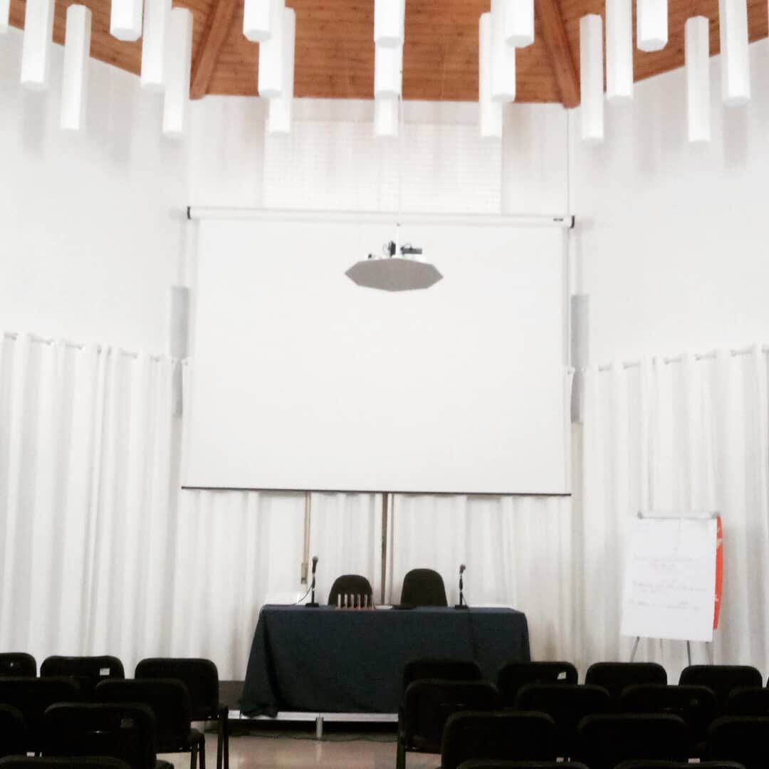 Sala multifunzionale del KISS con schermo per proiezioni e sedute per il pubblico