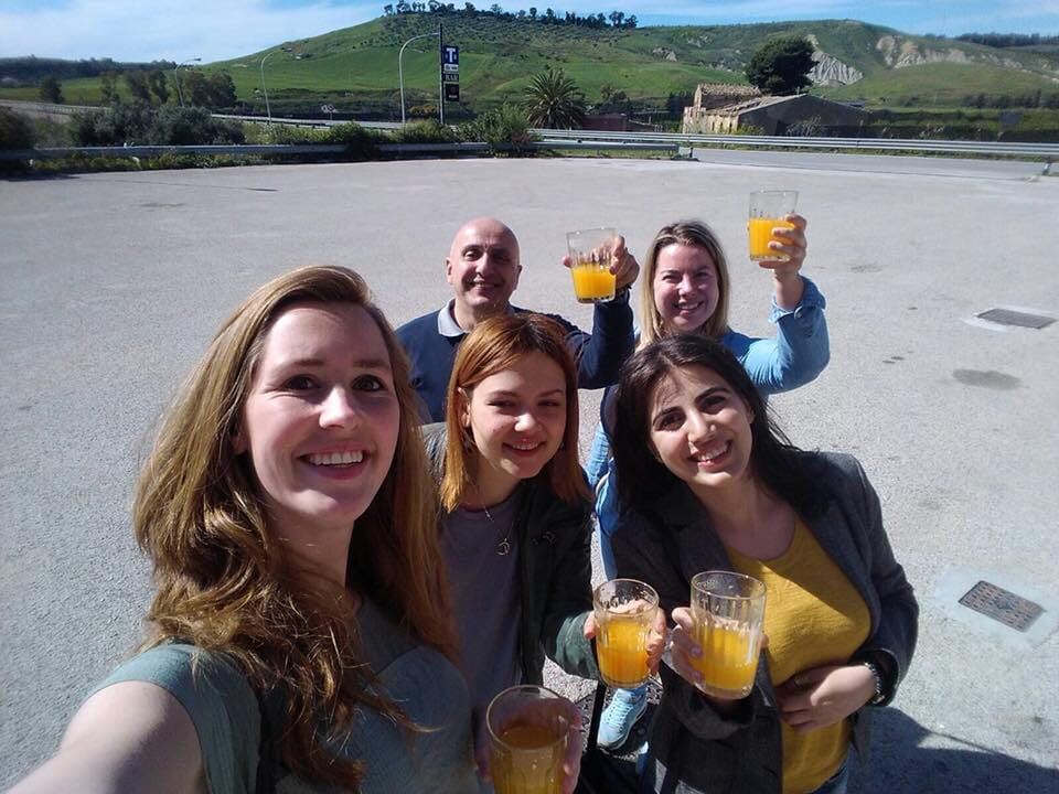 Gruppo di volontari e partecipanti al Servizio Volontario Europeo in un brindisi con succo d'arancia
