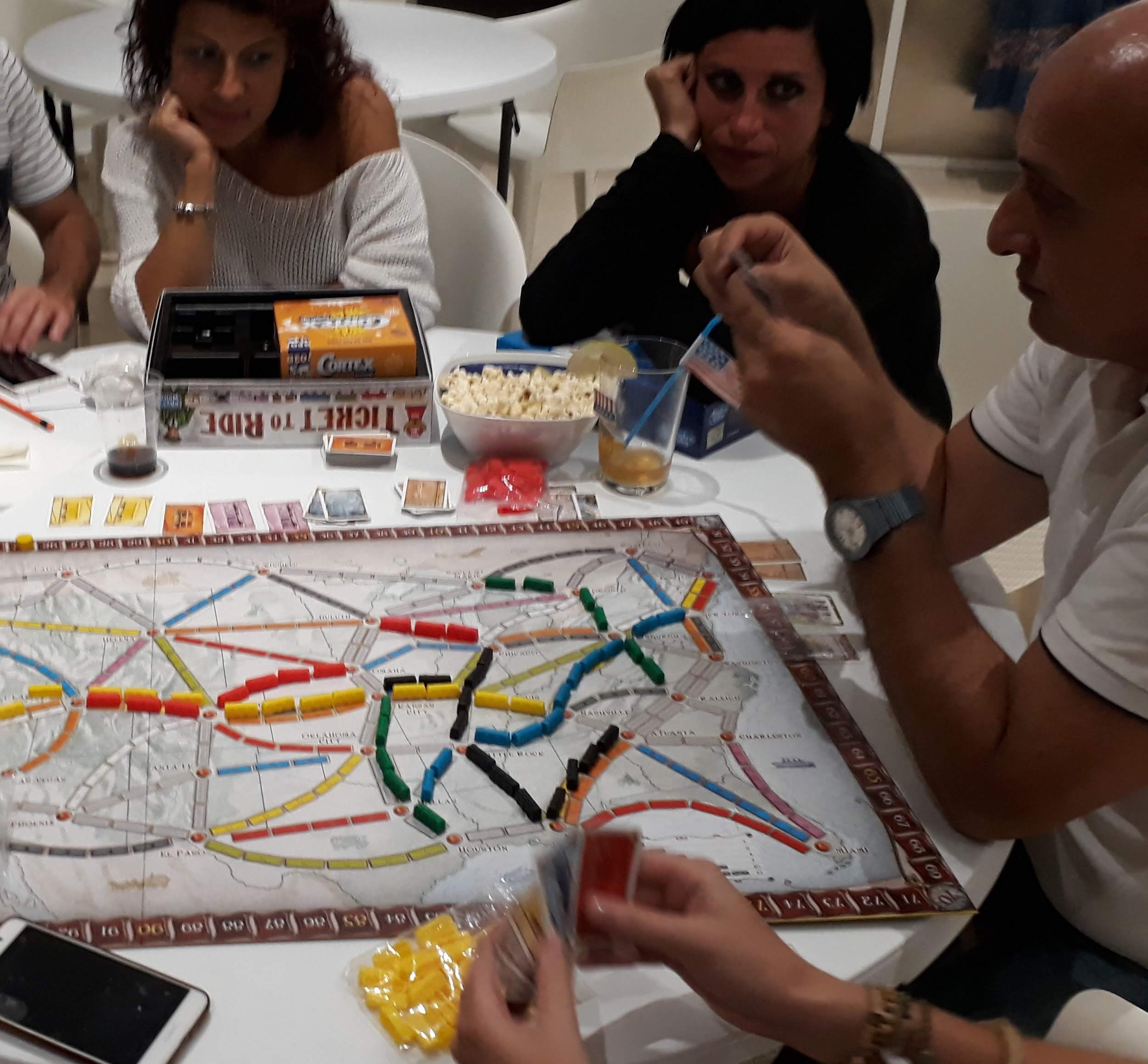 Gruppo di amici attorno al tavolo durante una partita a Ticket to Ride